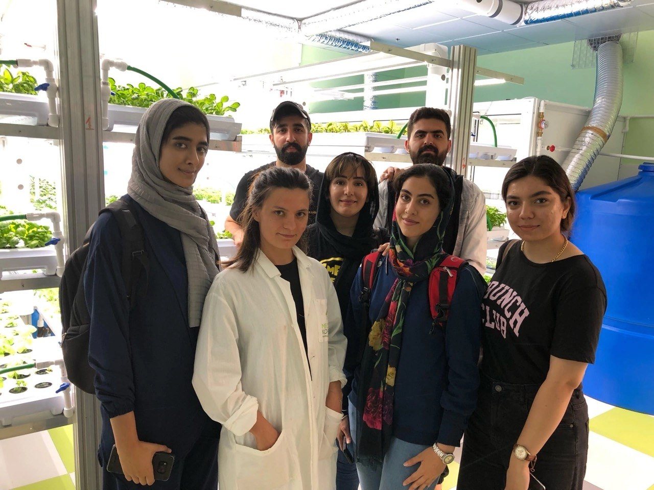 Maya with students in an indoor farming lab