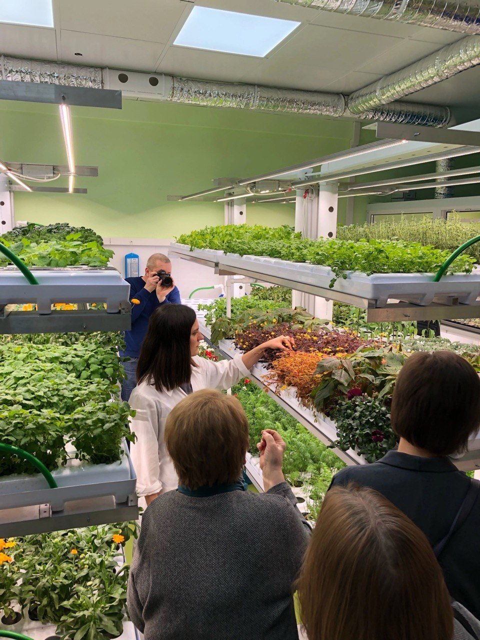 Maya demonstrating crops on indoor farming racks